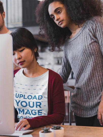 Asian Girl Wearing a Tshirt Mockup while Learning from her Coworker a20421