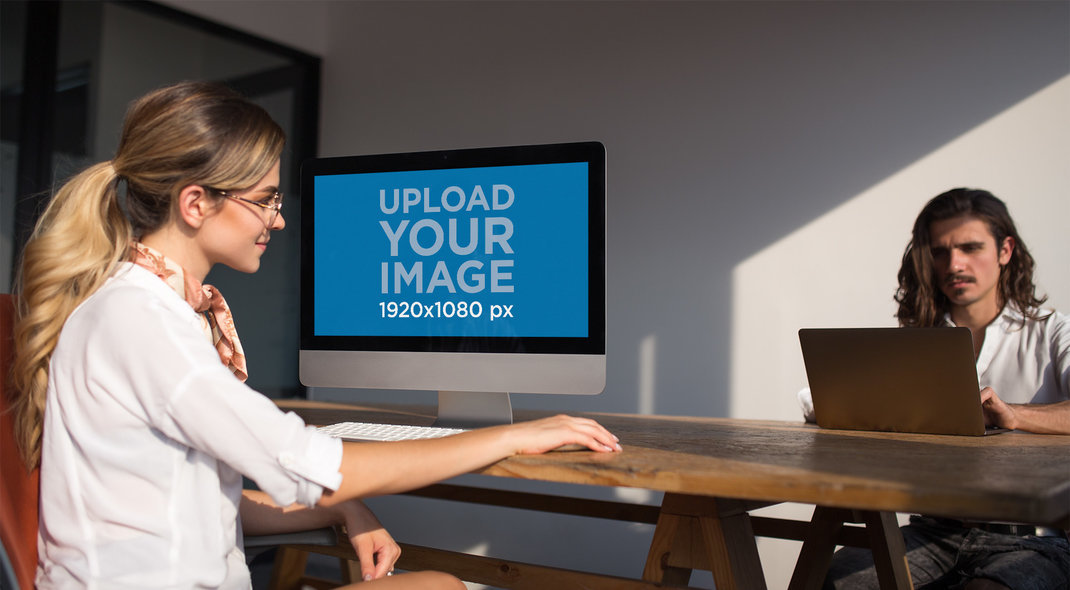 Woman Working with an iMac Mockup Near her Coworker