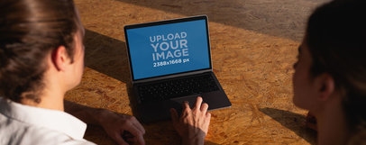 Coworkers Using a MacBook Mockup on a Recycled Wooden Desk a20769