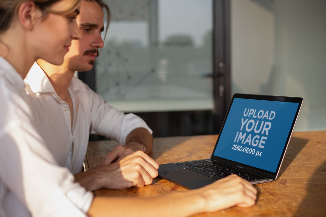 Man and Woman Working with a MacBook Mockup on a Wooden Desk