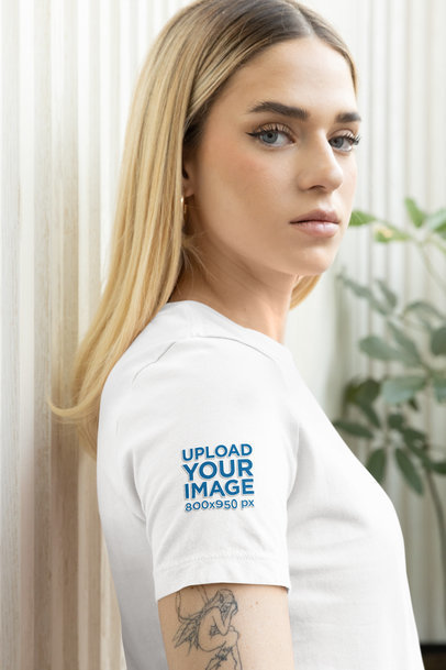 Mockup of a Woman with an Arm Tattoo Wearing a T-Shirt with a Customizable Sleeve