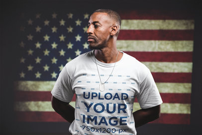 Man Wearing a Tshirt Mockup Standing Against an American Flag