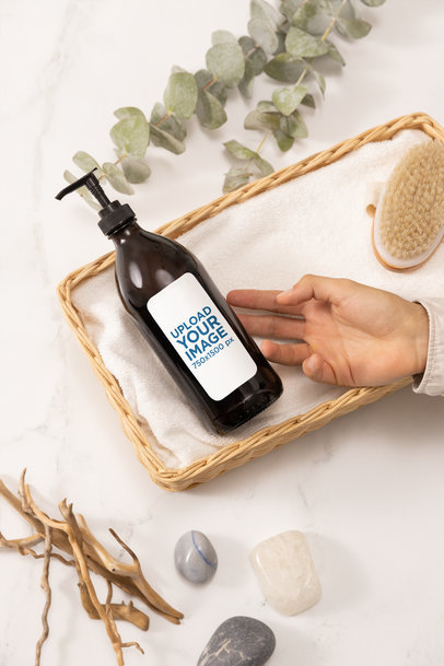 Mockup of a Person Touching a Glass Pump Bottle