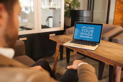 MacBook Mockup Lying on a Wooden Bench Near a Man