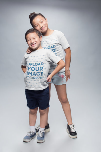 Mockup of Happy Kids Wearing Round Neck Tees at a Photo Studio