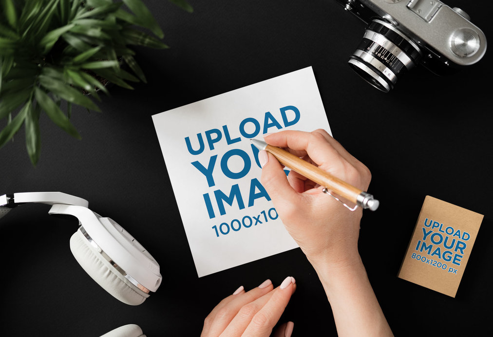 Mockup of a Person Using a Paper Sketch Featuring a Vertical Business Card and an Old Camera