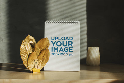 Mockup of a Notebook Placed on a Wooden Table Featuring Some Leaves m32055 r-el2