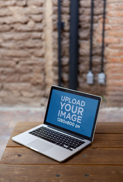 Open MacBook Mockup Standing on the Corner of a Wooden Table