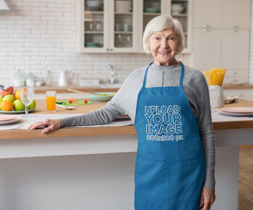Apron Mockup Featuring a Smiling Senior Woman Posing in a Kitchen