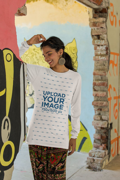 Bella Canvas Long Sleeve Tee Mockup Featuring a Smiling Woman Standing Near a Painted Wall