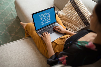 MacBook Mockup of a Woman Working while Sitting on a Sofa