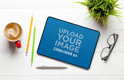 Mockup of an iPad Placed on a White Desk Featuring a Plant and a Cup of Coffee m32020 r-el2