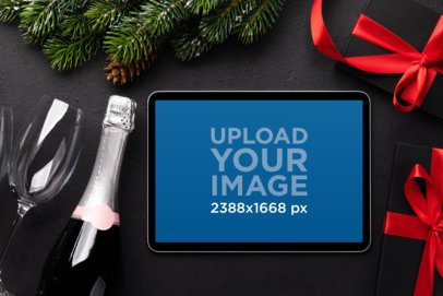 Christmas-Themed Mockup of an iPad Placed Next to a Bottle of Champagne m32023 r-el2