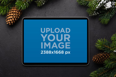 Mockup of an iPad Placed on Black Surface Surrounded by Christmas Decor m32024 r-el2