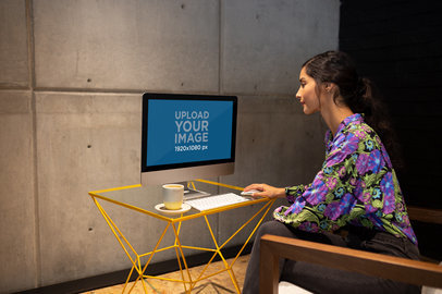 Woman Working on an iMac Mockup Sitting on an Armchair