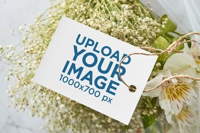 Mockup of a Wedding Program Placed on a Bouquet
