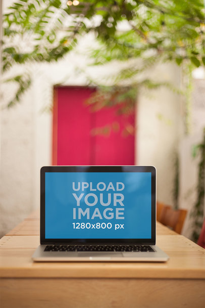 Mockup of a MacBook Standing on a Wooden Table