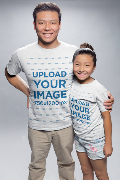 Mockup of an Asian Man Hugging his Daughter Wearing T-Shirts at a Photo Studio