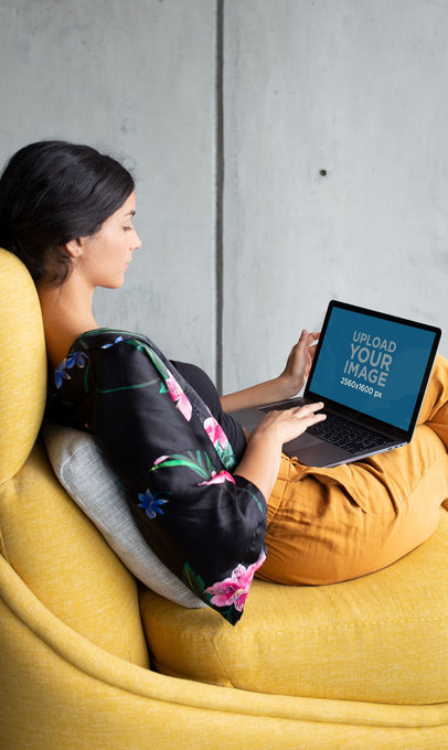 Woman Sitting on a Yellow Sofa Working with a MacBook Mockup