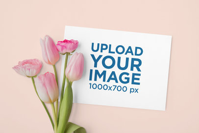 Mockup of a Wedding Program Placed Next to Pink Flowers