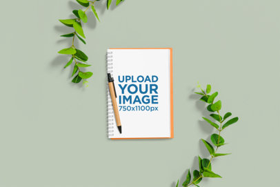 Mockup of a Notebook Placed on a Customizable Surface Featuring Two Plants
