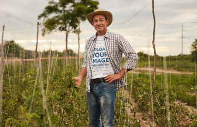 Round-Neck Tee Mockup of a Senior Farmer Standing on His Crops