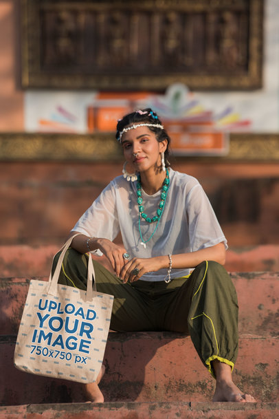 Tote Bag Mockup Featuring a Smiling Woman Sitting on the Street