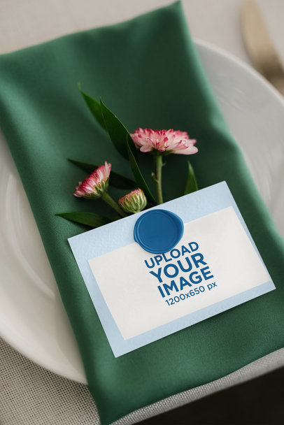 Mockup of a Wedding Program Placed on a Cloth Napkin With Flowers