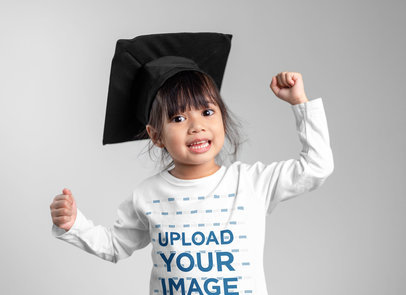 Long-Sleeve Tee Mockup Featuring a Cheerful Little Girl With a Graduation Hat