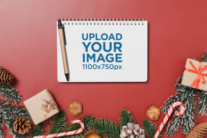 Christmas-Themed Mockup of a Notebook Lying on a Red Background With Holiday Ornaments m32122 r-el2