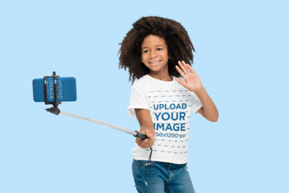T-Shirt and Phone Case Mockup of a Smiling Girl With an Afro Hairstyle Taking a Selfie
