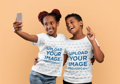 Round-Neck T-Shirt Mockup Featuring Two Happy Siblings Taking a Selfie