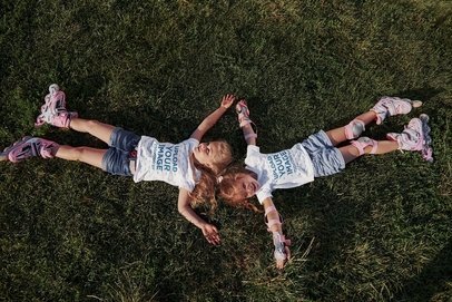 Round-Neck T-Shirt Mockup Featuring Two Siblings Lying on the Grass