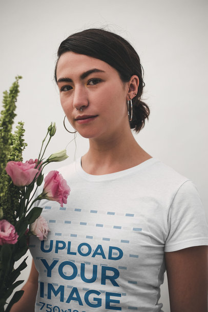Mockup of a Smiling Asian Woman Wearing a T-Shirt Holding Flowers
