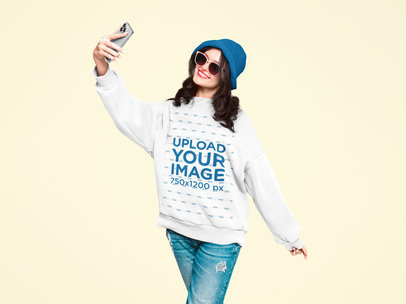 Sweatshirt Mockup of a Smiling Woman Taking a Selfie at the Studio
