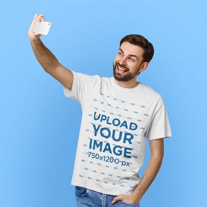 T-Shirt Mockup of a Cheerful Bearded Man Taking a Selfie in a Studio