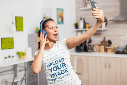 T-Shirt Mockup of a Woman with Headphones Taking a Selfie at Home