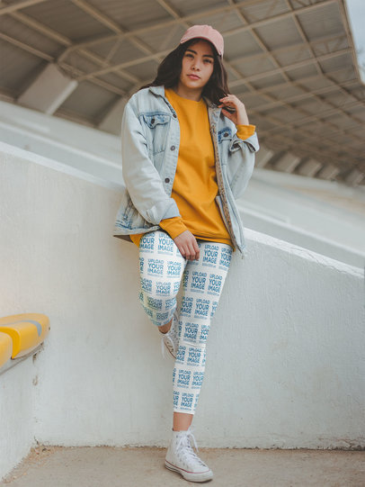 Mockup of a Girl Wearing Women's Sports Leggings and a Hat at a Stadium