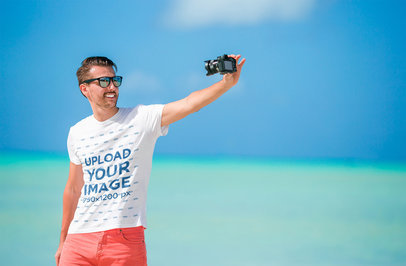 T-Shirt Mockup of a Man with Sunglasses Taking a Selfie at the Beach
