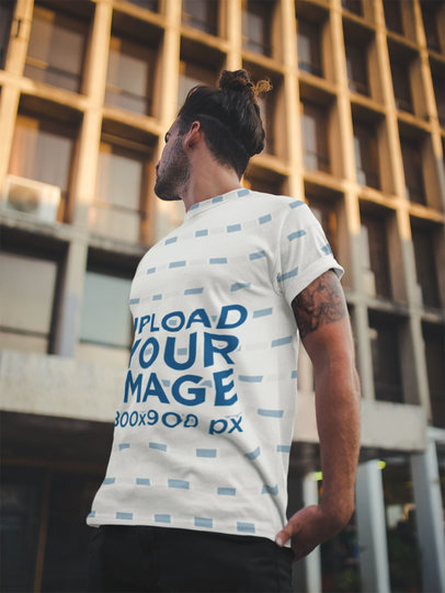Sublimated Round Neck Tee Mockup Featuring a Long-Haired Man Outside a Big Building