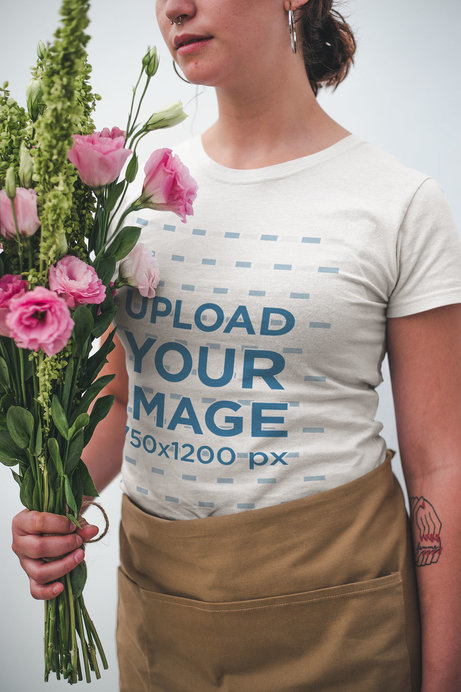 Closeup Mockup of a Woman Wearing a T-Shirt while Holding a Bouquet of Flowers