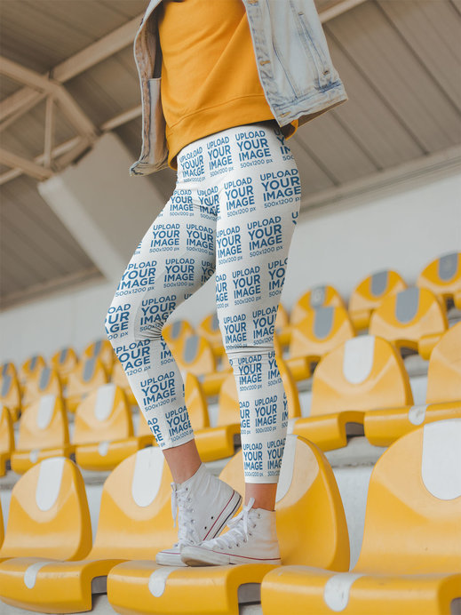 Women's Leggings Mockup of a Girl Standing on Yellow Stadium Seats