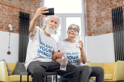 T-Shirt Mockup Featuring a Smiling Senior Couple Taking a Selfie