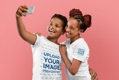 T-Shirt Mockup Featuring Two Happy Siblings Taking a Selfie at a Studio