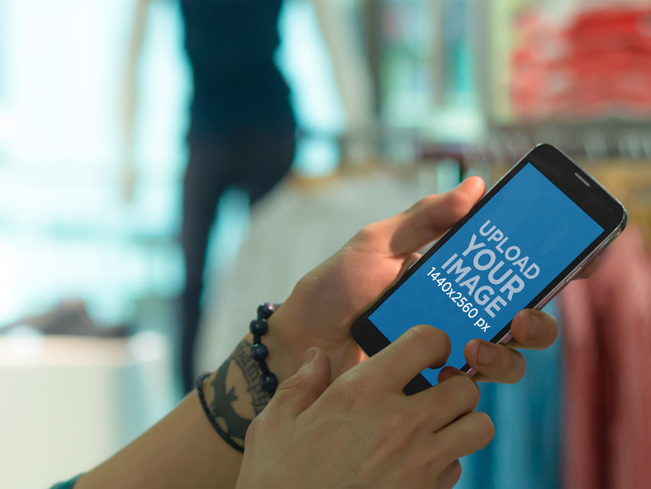 Mockup of a Tattooed Person Holding an Android Phone