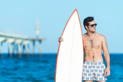 Swim Trunks Mockup Featuring a Serious Man Holding a Surfboard m34471 r-el2