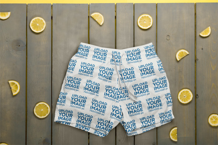 Mockup of a Pair of Swim Trunks Placed on a Wooden Surface Surrounded by Lemon Slices