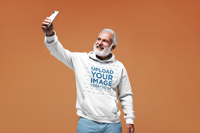 Pullover Hoodie Mockup of a Bearded Senior Man Taking a Selfie