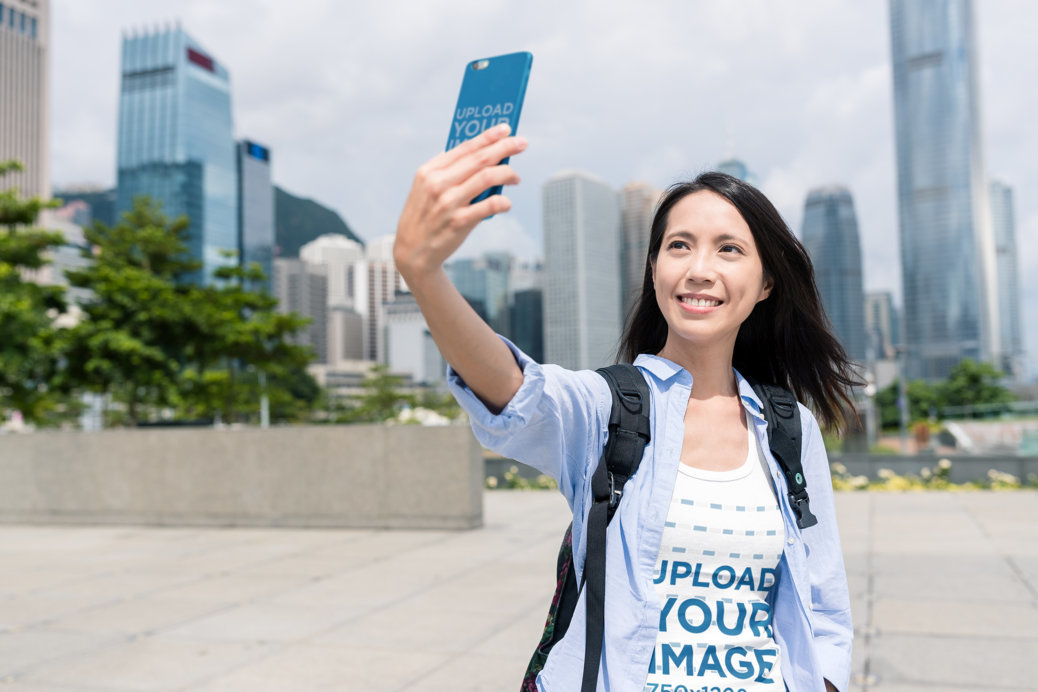 Tank Top and Phone Case Mockup Featuring a Joyful Woman Taking a Selfie