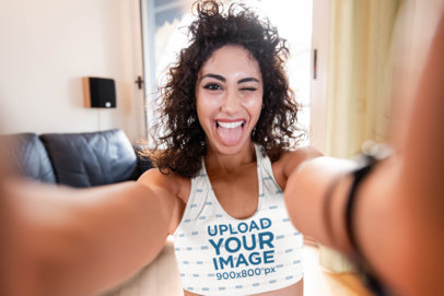 Selfie Mockup of a Woman with Curly Hair Wearing a Sports Bra